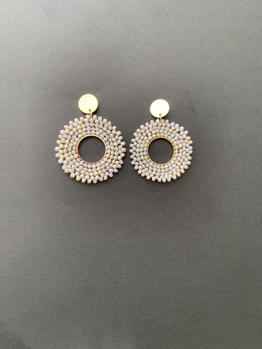 Large open circle hoop earrings wrapped in uniform cream seed beads with flat gold disc stud top.