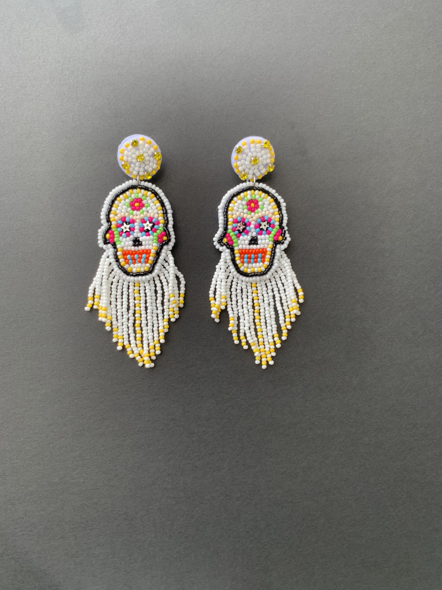 Beaded sugar skull earrings with colourful face detail and long white and yellow seed bead fringe tassel.
