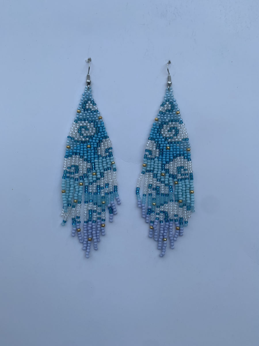 Long fringe earrings with turquoise floral scroll motif on white ground, ombre fringe fading to lavender tips with gold accent beads, wire hook.