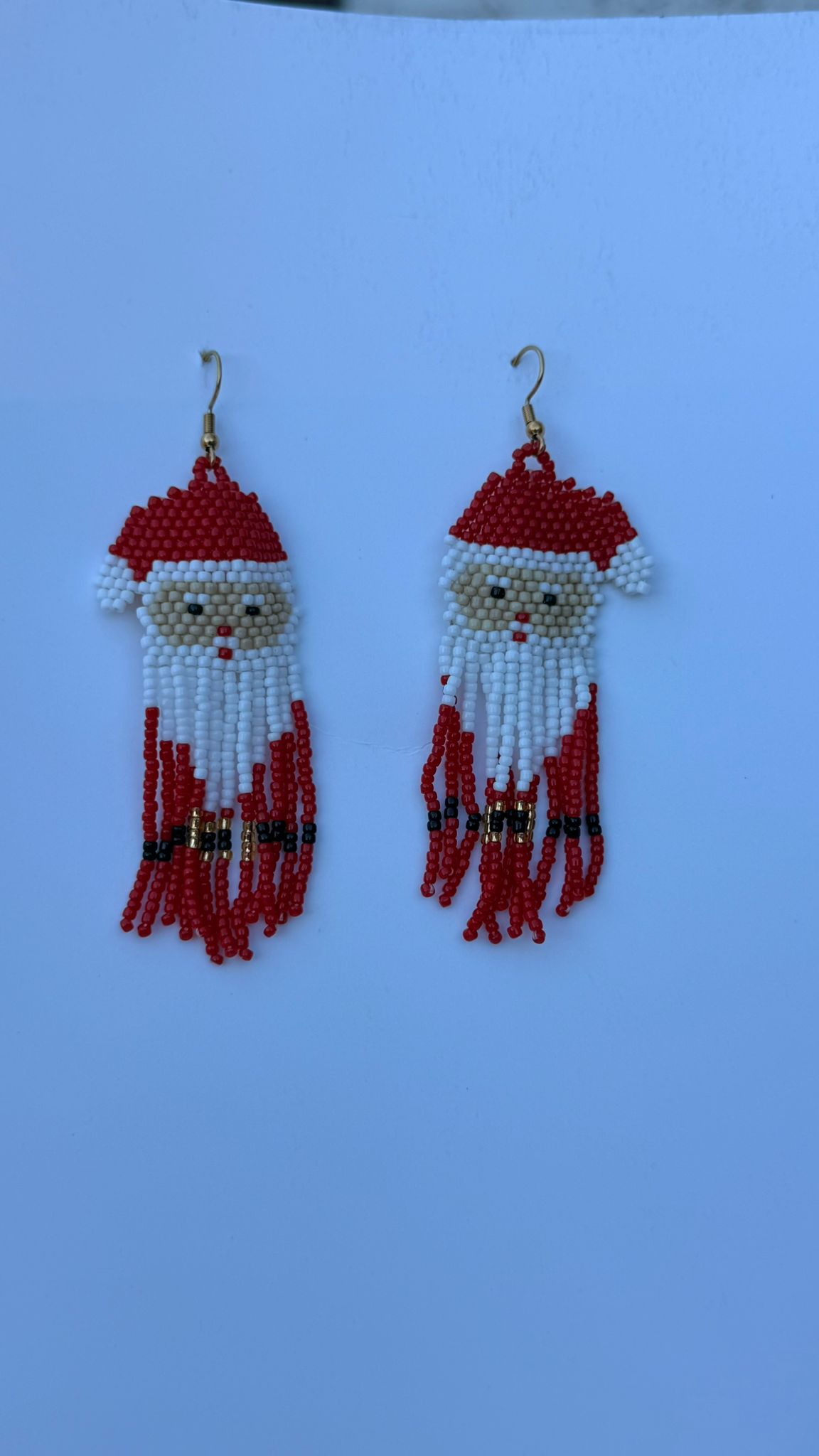 Pair of red beaded Santa earrings with white beards and tassels.